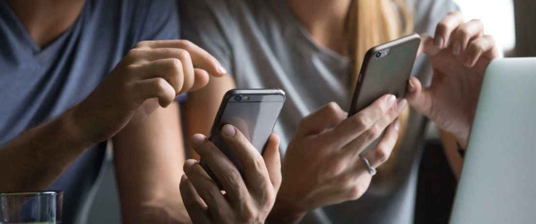 Man and woman using smartphones discussing mobile apps, close up